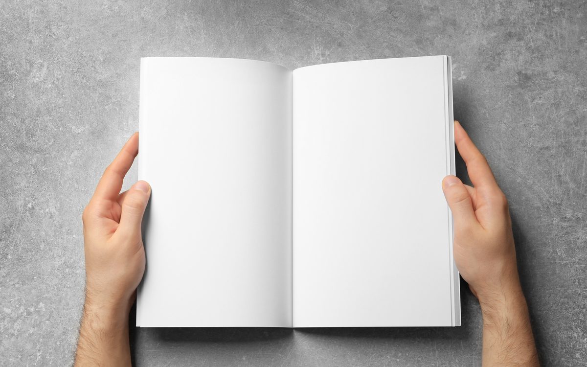 Hands holding an open bound proposal document